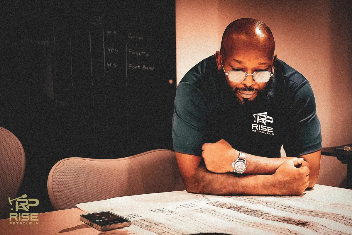 Owner Tracy Hairston reviewing well logs in a Rise Petroleum polo